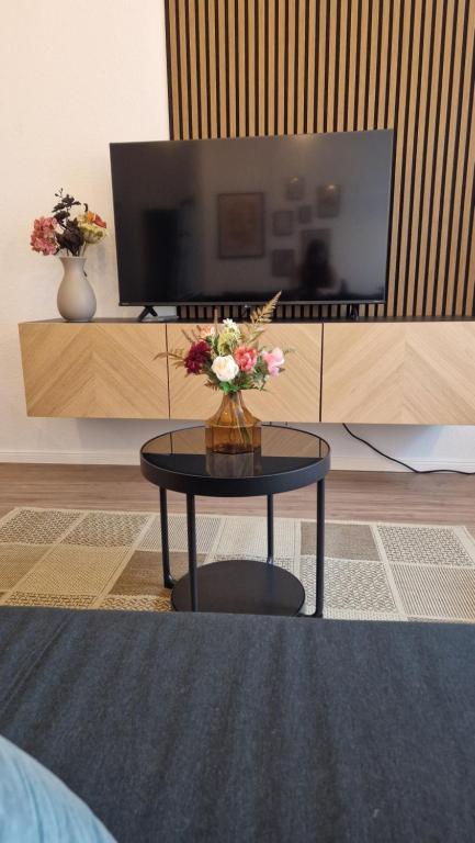 a living room with a table with flowers on it at Altstadt Apartment beim Schlossgarten in Schwerin