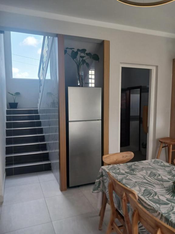 a kitchen with a refrigerator and a table and a staircase at Midhan villa in Rivière Noire