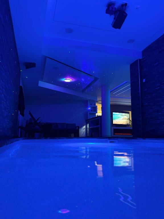 a swimming pool in a room with blue lights at N3XT-LEVEL Pool in Praia
