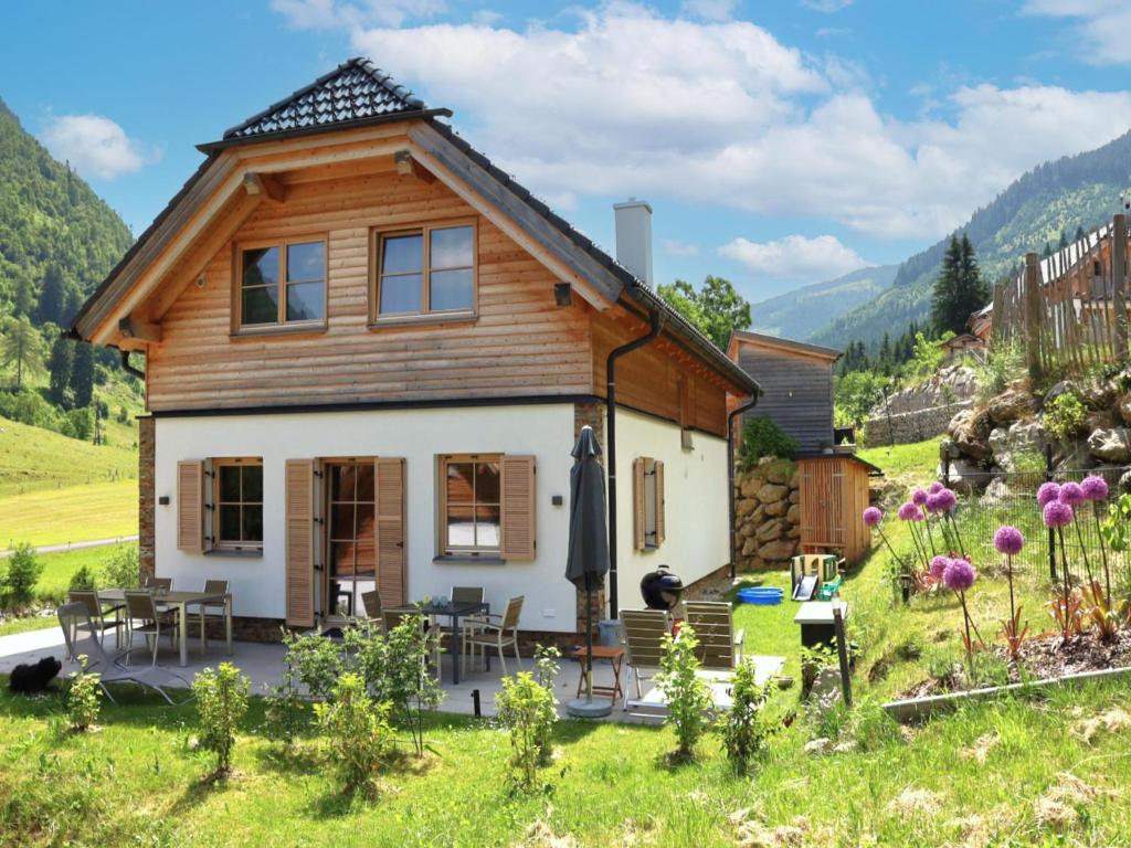 a small house in a field with mountains in the background at Haus Hestia in Donnersbachwald