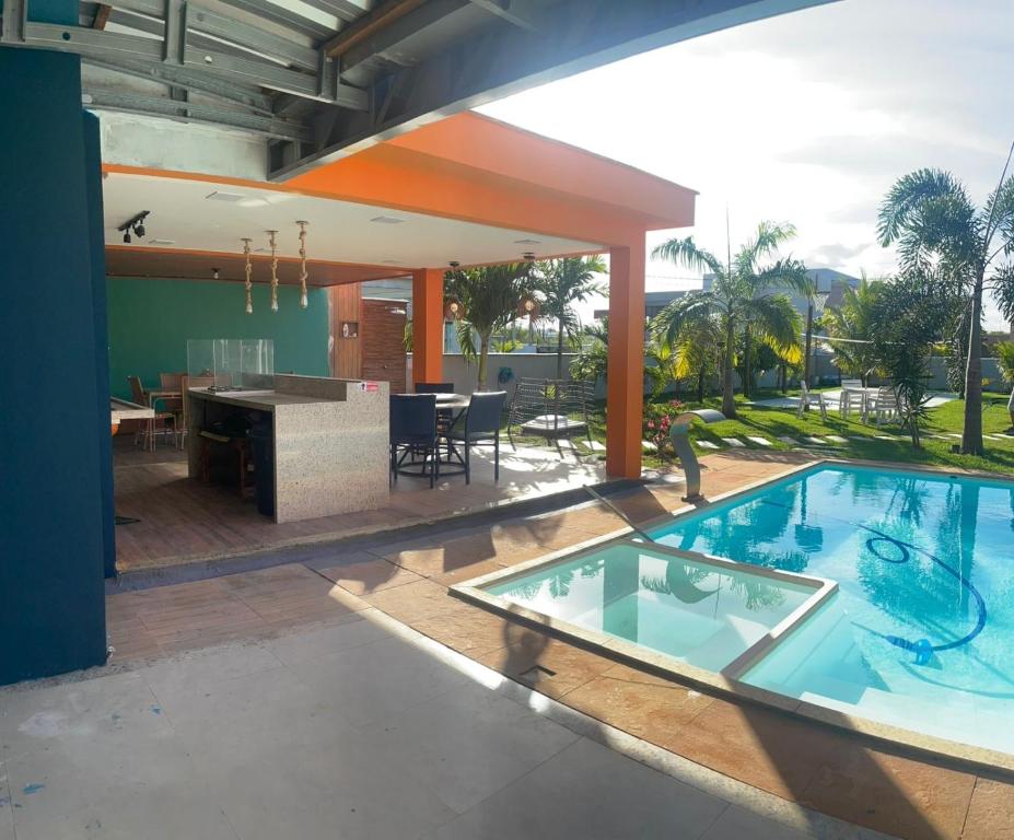 a house with a swimming pool in the middle of a yard at Casa Azul in Camaçari