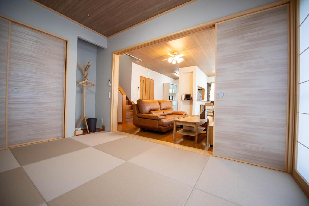 ein Wohnzimmer mit Ledersessel und Schiebetüren in der Unterkunft 飛梅の宿Tobiume inn in Dazaifu