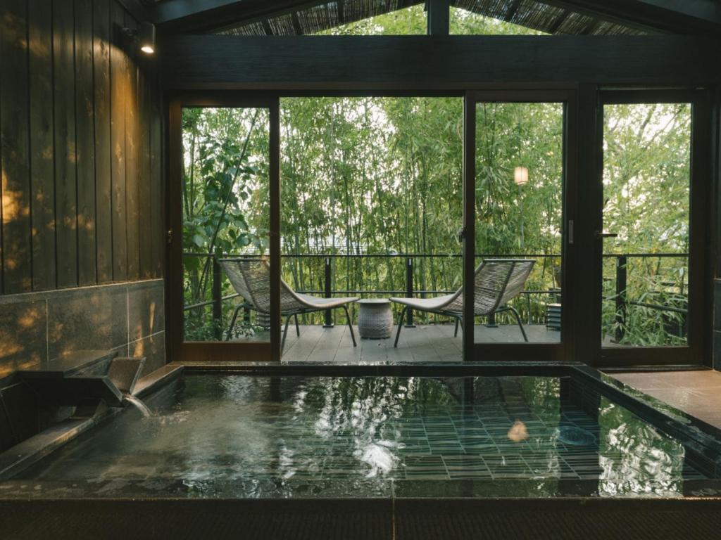 une piscine dans une maison avec vue sur les arbres dans l'établissement Ujosouan, à Kyōtango
