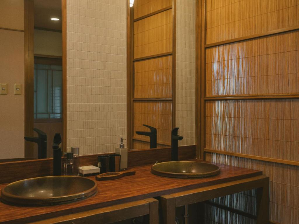une salle de bains avec deux lavabos et un grand miroir dans l'établissement Ujosouan, à Kyōtango