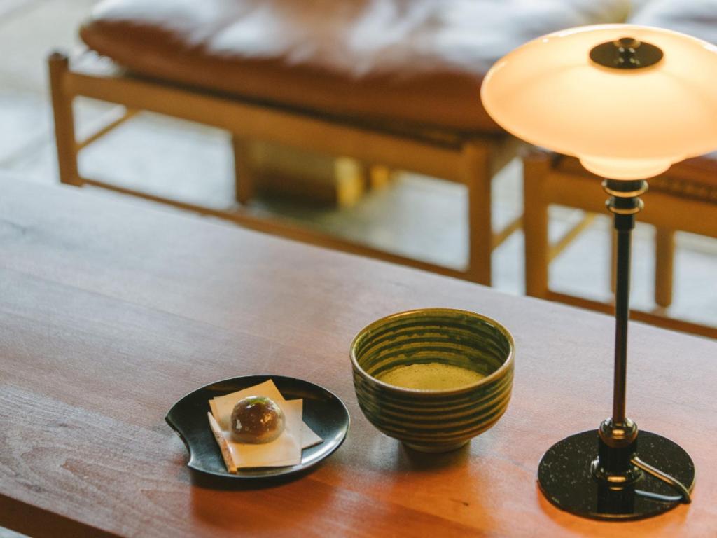 - une table avec une lampe et un bol de nourriture dans l'établissement Ujosouan, à Kyōtango