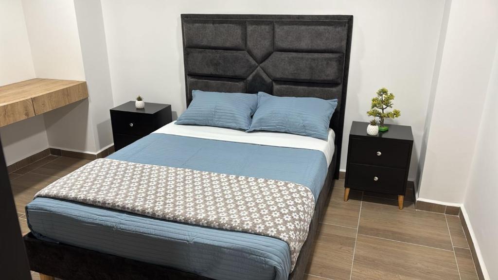 a bedroom with a bed with a black headboard and two night stands at Edificio Living 42 - Apto 105 in Estación El Salto