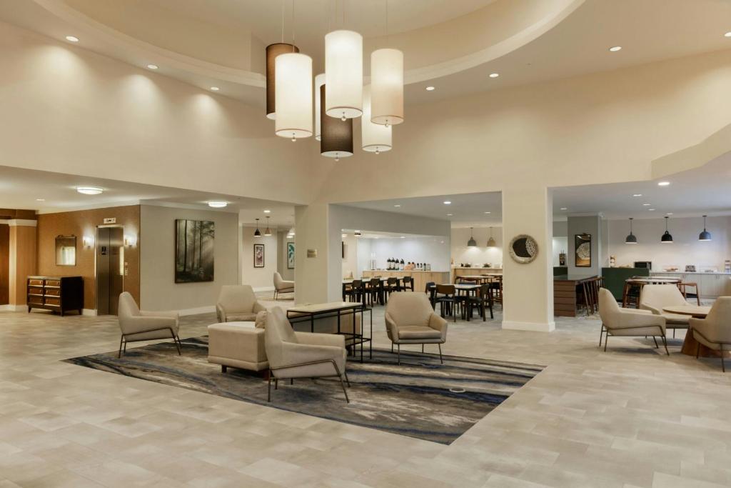 Un vestíbulo de un hotel con sillas y mesas. en Fairfield Inn & Suites by Marriott Miami Airport South, en Miami