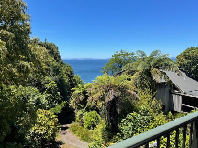 a house on a balcony with a view of the ocean at Pukawa Villas Formerly Oreti Village Resort in Kuratau