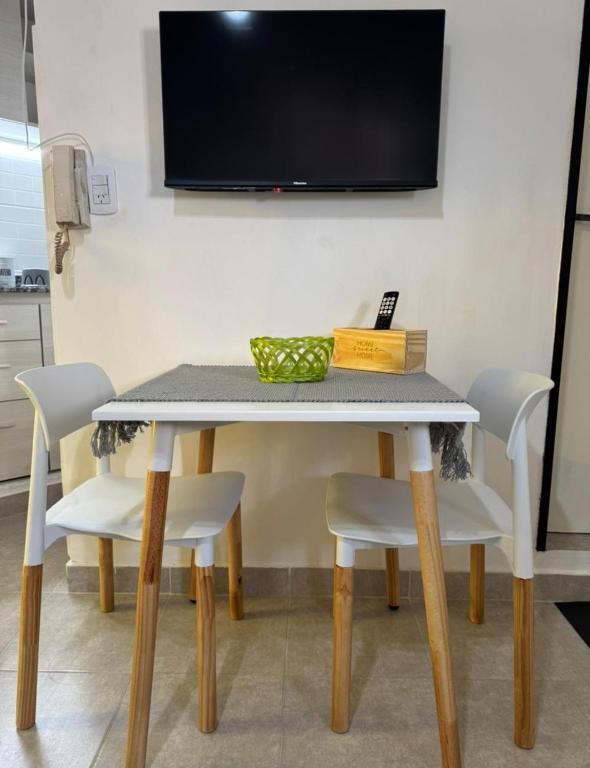 a dining room table with chairs and a television on the wall at Departamento Bonito Excelente Ubicación in Morón