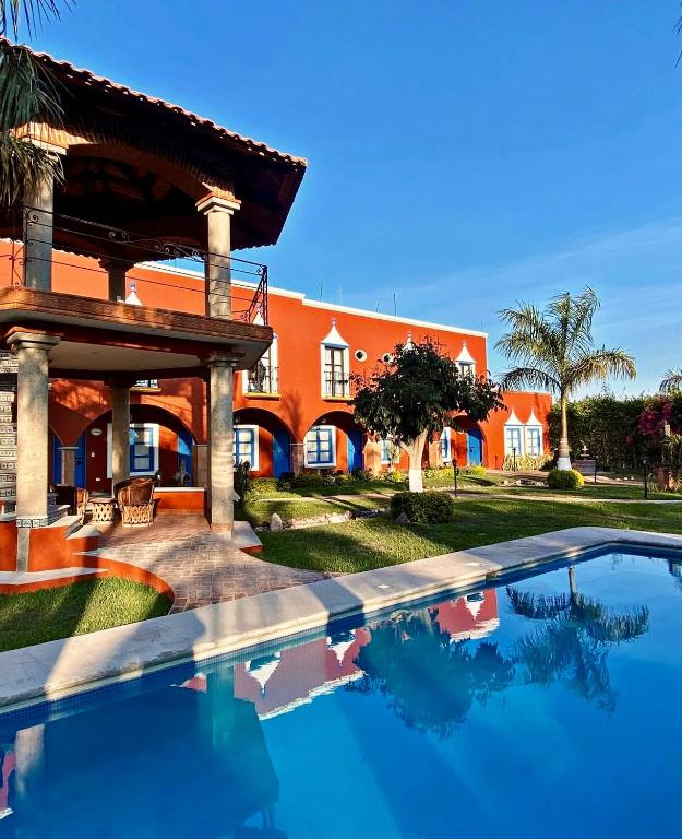 a swimming pool in front of a house at Hotel Finca San José in Teotlalco
