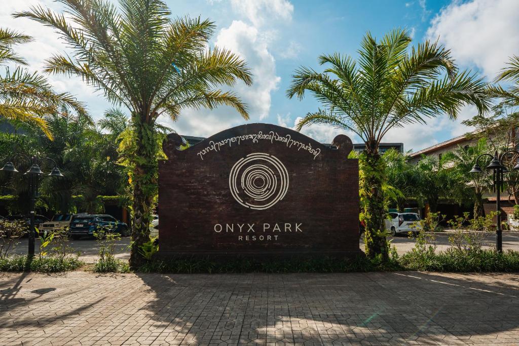 a park sign in front of a building with palm trees at ONYX PARK RESORT Ubud in Ubud
