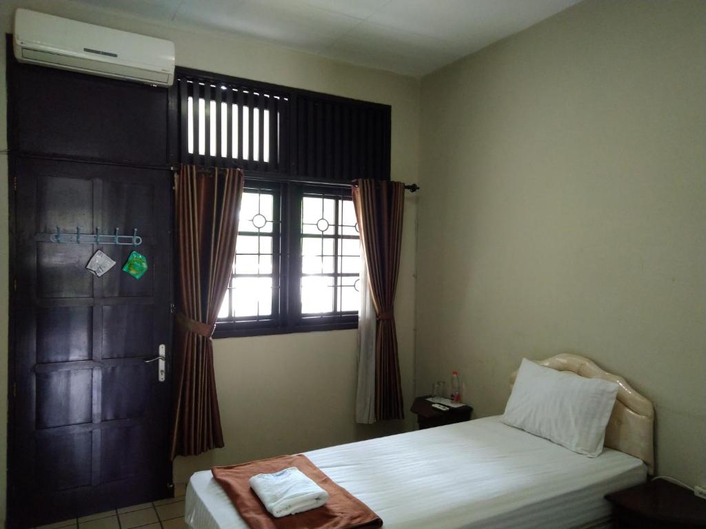 un dormitorio con una cama y una ventana en Wisma Colomadu, en Colomadu