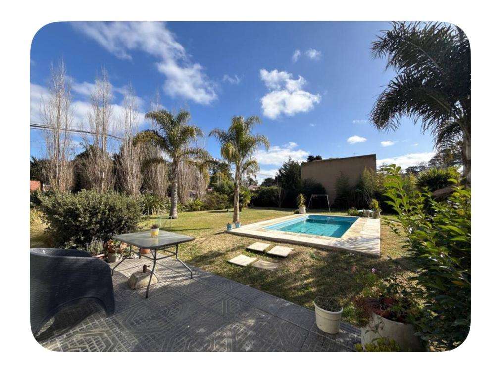 a backyard with a swimming pool and a table and a table sidx sidx at Acantilados mar y pileta in Mar del Plata