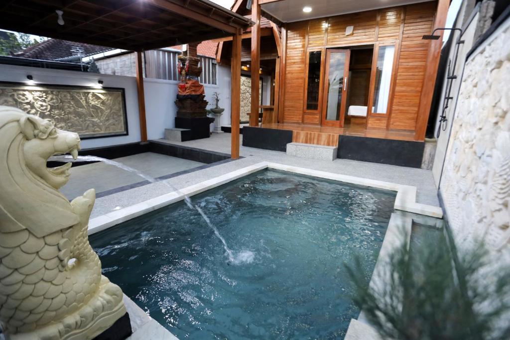 Una piscina en una casa con una fuente de dragón. en Villa Aditya, en Babakan Sangsit