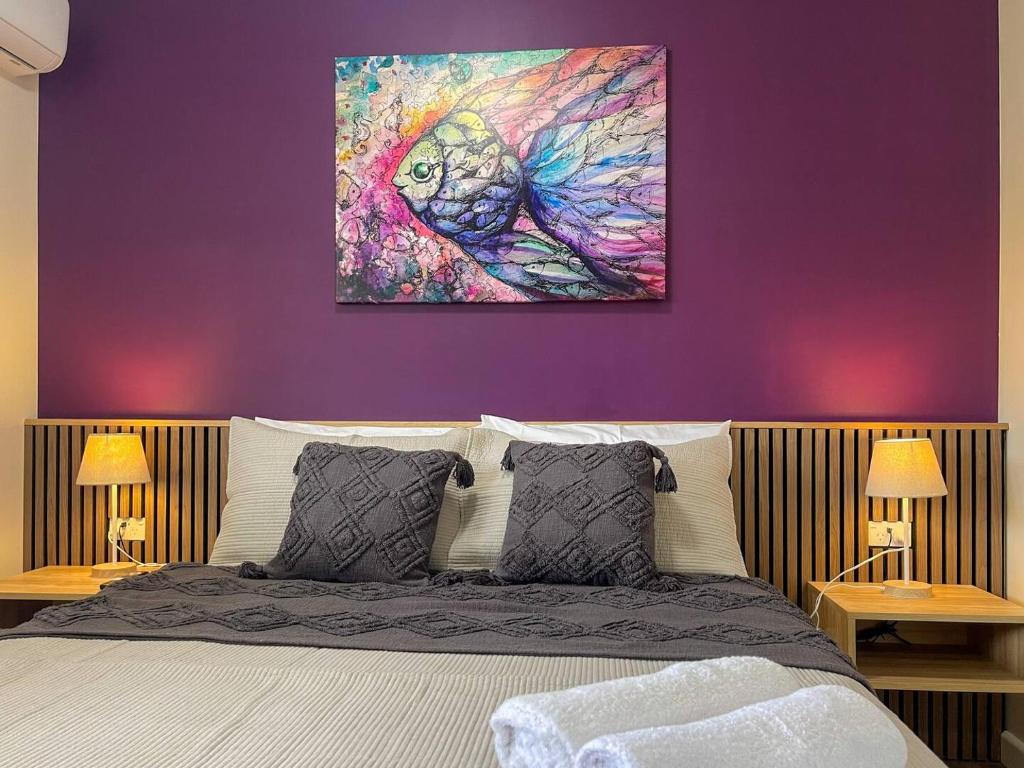 une chambre avec un lit avec un mur violet dans l'établissement Quarterdeck Apartment 7 - Family Stay, à Gladstone