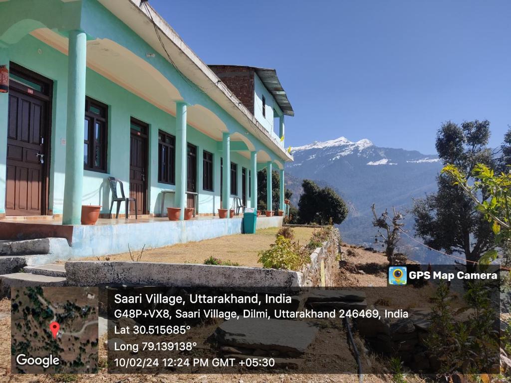 a house on a hill with mountains in the background at Nanda Devi Home Stay Sari Chopta in Sari