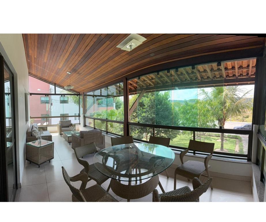 a dining room with a glass table and chairs at Flat espaçoso e confortavel no hotel Canarius Gravata in Gravatá