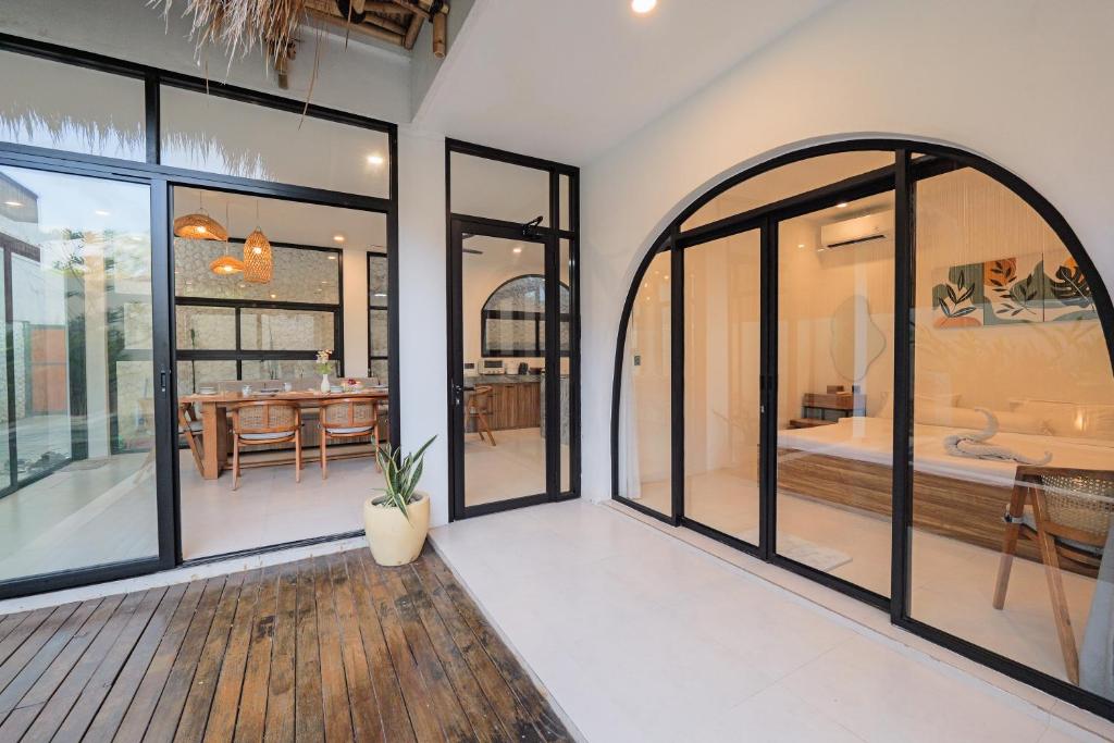 an open living room with large windows and a dining room at 4BR Modern Villa walking dist to Sidewalk Jimbaran in Jimbaran