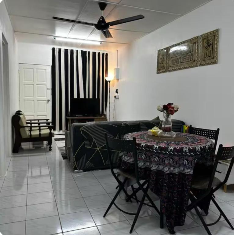 a living room with a table and a couch at Aileen Homestay Swimming Pool in Batu Gajah