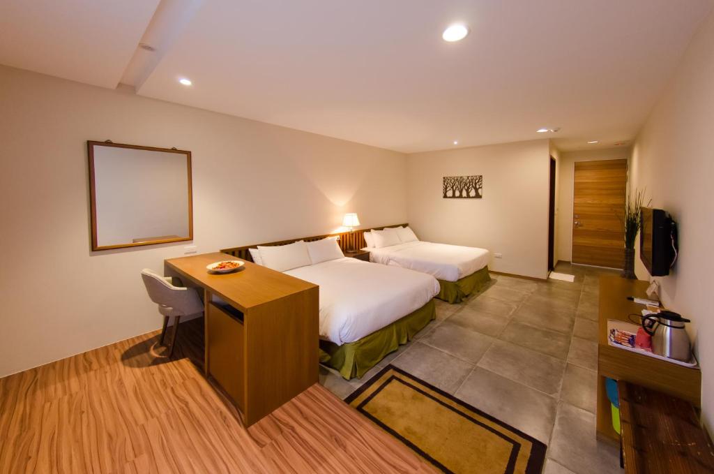 a hotel room with a bed and a desk at Palm Tree Hotel Kenting in Kenting