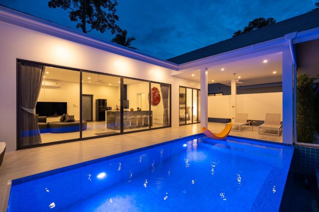a swimming pool in the backyard of a house at night at Osho Luxury Villa in Hinkong