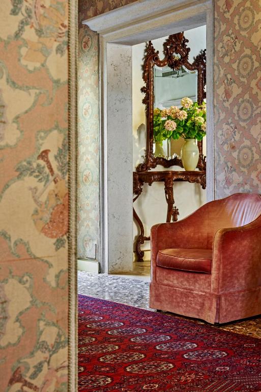 a living room with a chair and a mirror at Hotel Gardena in Venice