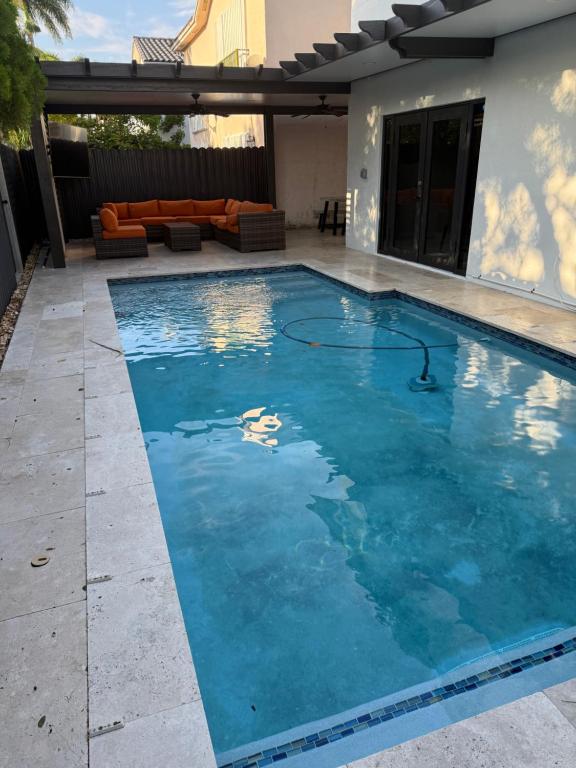 a swimming pool with blue water in a backyard at Villa Miami Lakes 2 in Hialeah
