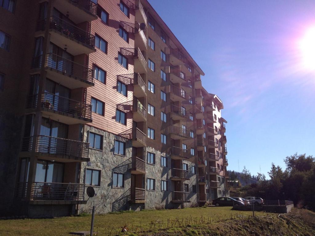 un edificio alto con balcones a un lado. en Apartment Villarrica Holidays, en Villarrica