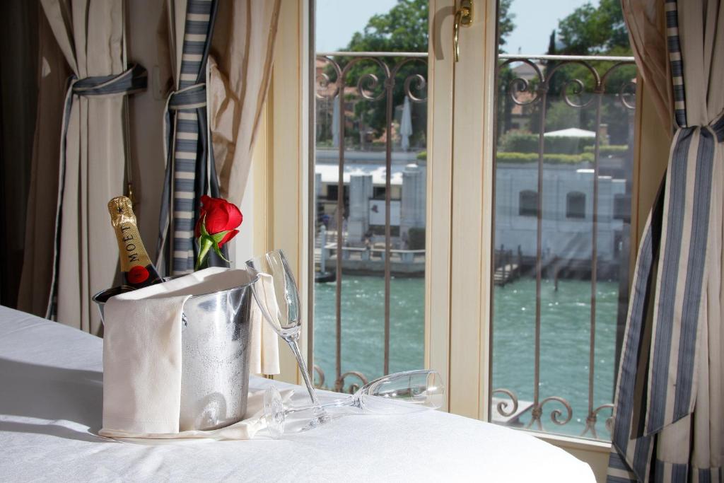 una botella de vino en una bolsa sobre una mesa con una ventana en Hotel Dei Dragomanni, en Venecia