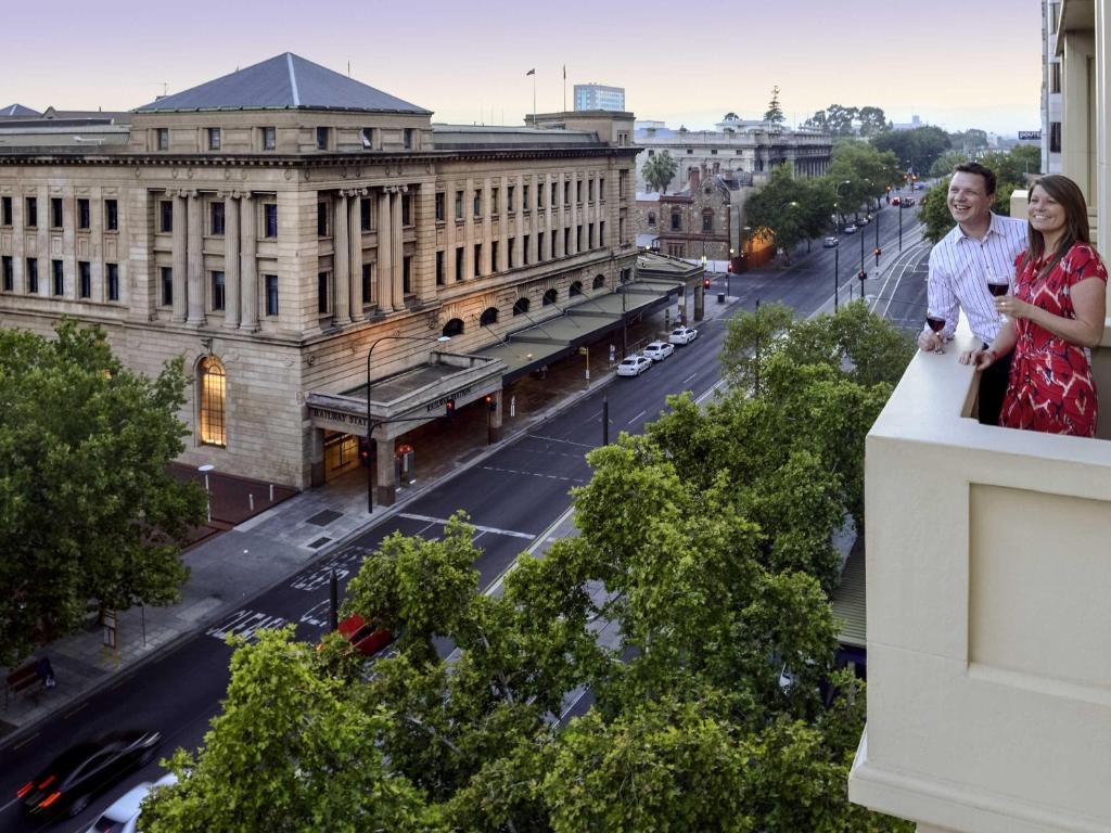 dos mujeres de pie en la cornisa de un edificio en Grosvenor Hotel Adelaide by Accor, en Adelaida