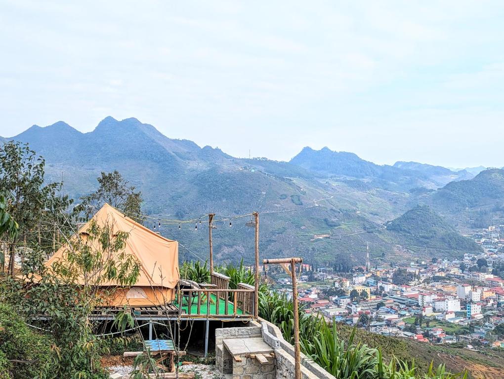 Mèo VạcにあるHà Giang Campingの山を背景にした丘の上の家
