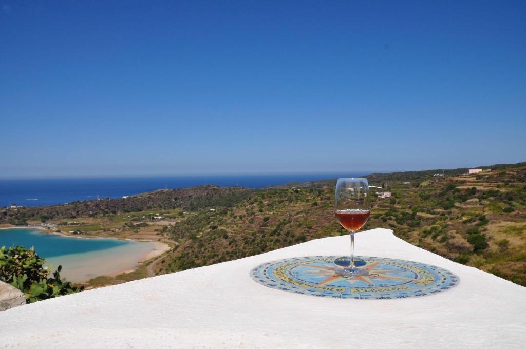 un bicchiere di vino seduto sopra un tavolo di Dammusi di Venere - U Locu a Pantelleria