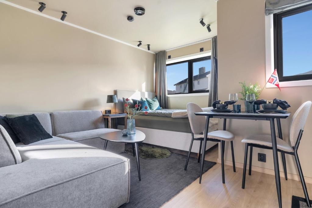 a living room with a couch and a table at Premium Studio by Arctic Seasons - A Cozy Luxury Escape at the Top of Tromsø in Tromsø
