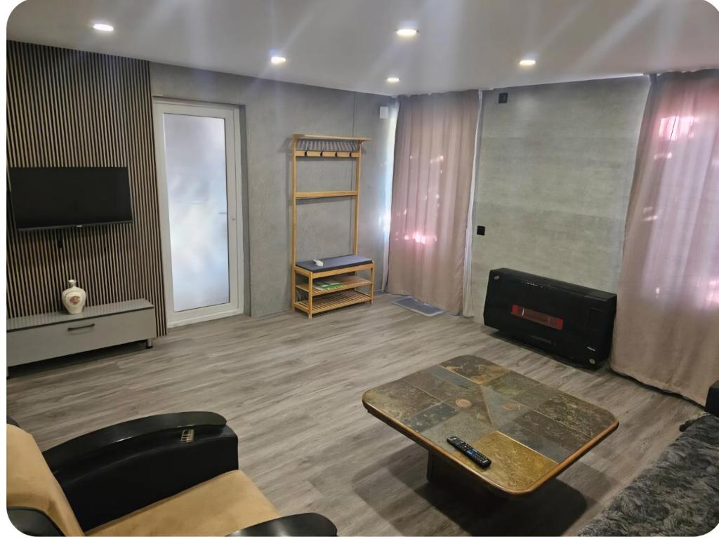 a living room with a table and a tv at George House in Batumi
