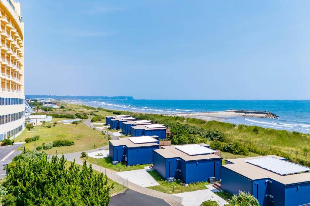 a row of blue buildings next to the beach at KAMENOI HOTEL Kujukuri in Asahi