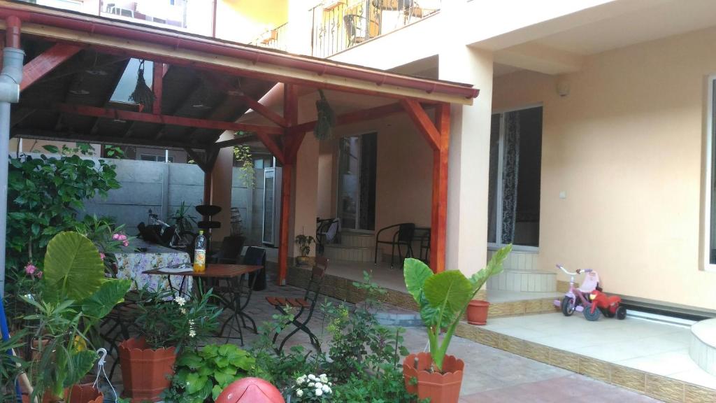 a house with a wooden pergola and a patio at Casa Dora Costinești in Costinesti
