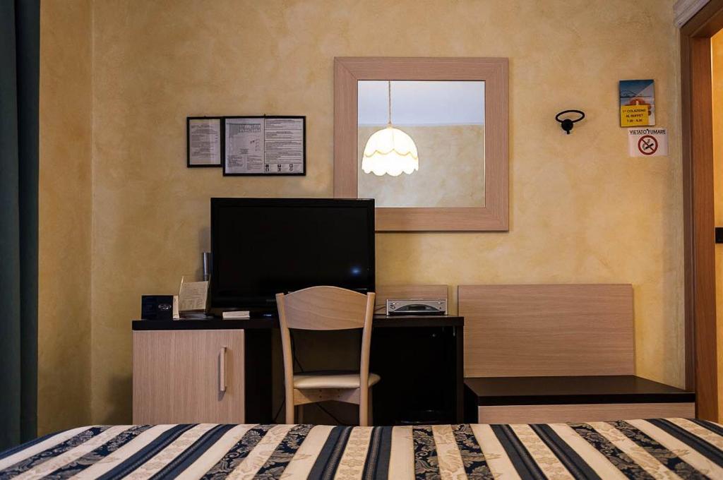 een slaapkamer met een bed en een bureau met een computer bij B & B Appia Antica in Mesagne