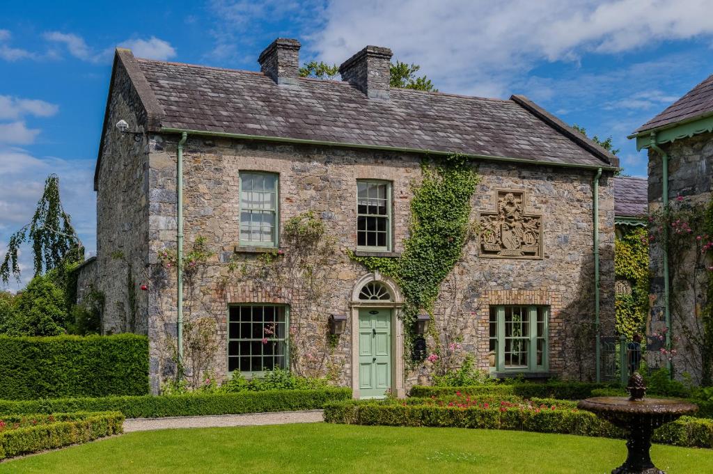 una vecchia casa in pietra con una porta verde di Cliff at Lyons a Celbridge