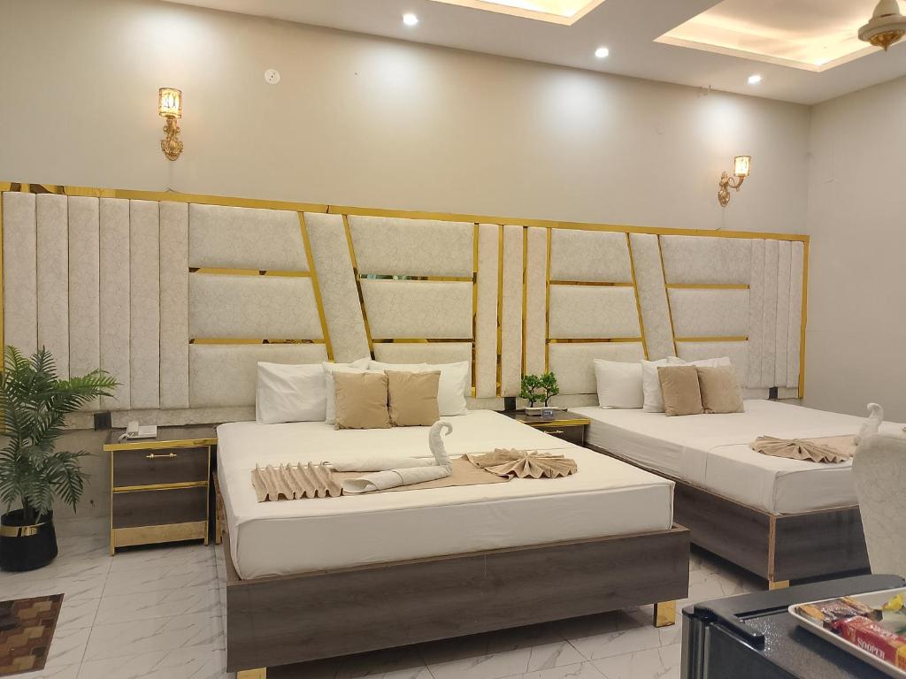 une chambre avec deux lits dans une chambre dans l'établissement Hotel Haven Suite, à Lahore
