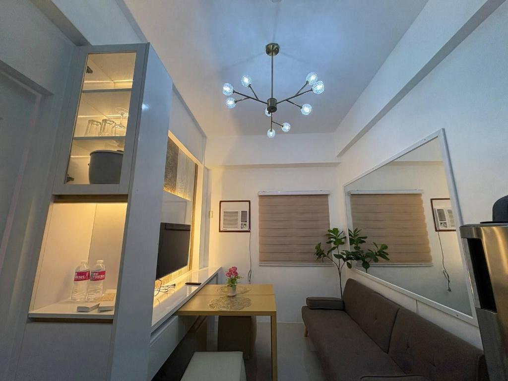 a room with a staircase with a table and a chandelier at Near Mactan International airport Condo with Private Entrance and Shared Pool in Gun-ob