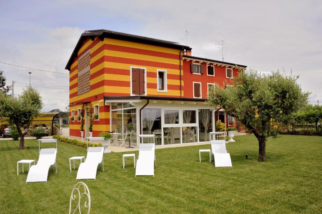 a building with a lot of white chairs in the grass at Corte Caselle in Sommacampagna