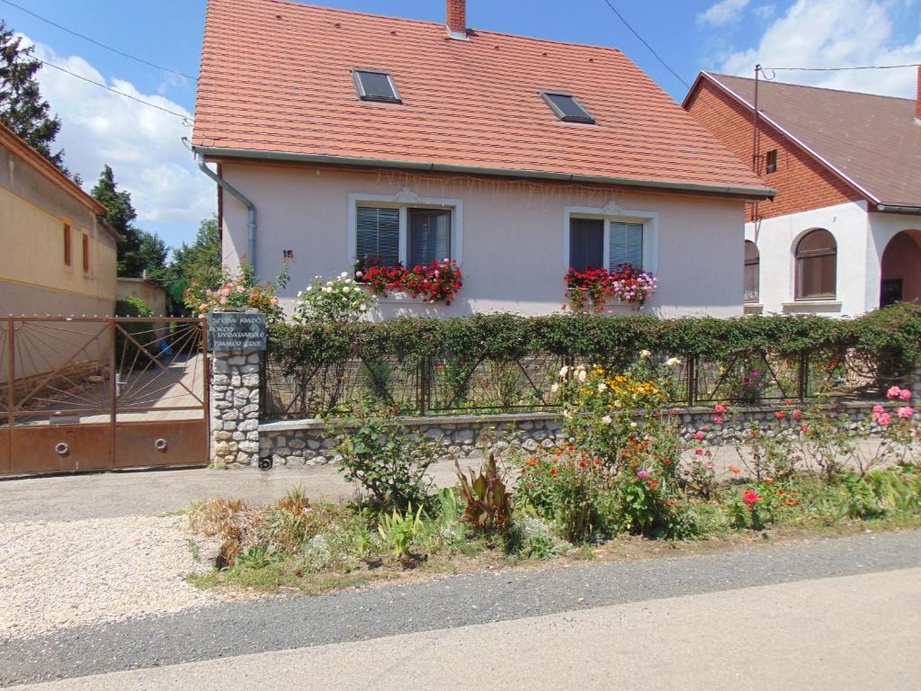 a house with a fence and flowers in front of it at Leander Apartman in Sárvár