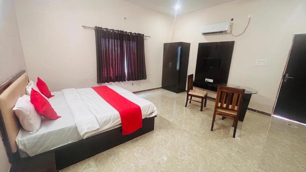 une chambre avec un lit, un bureau et une télévision dans l'établissement Badal Valley Resort, à Kumbhalgarh