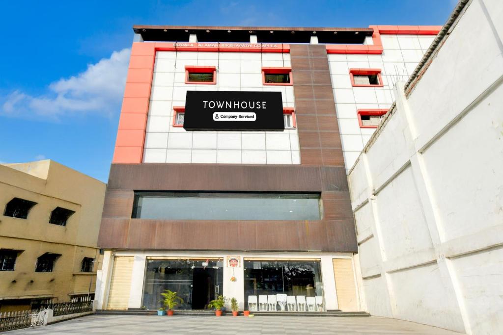 a building with a sign on the side of it at Super Townhouse Nagole RTO Office in Upal