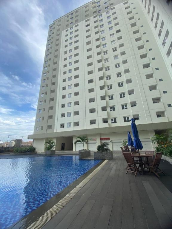 a large white building with chairs and a swimming pool at Antareja LoftVilles By Reccoma in Dukuh