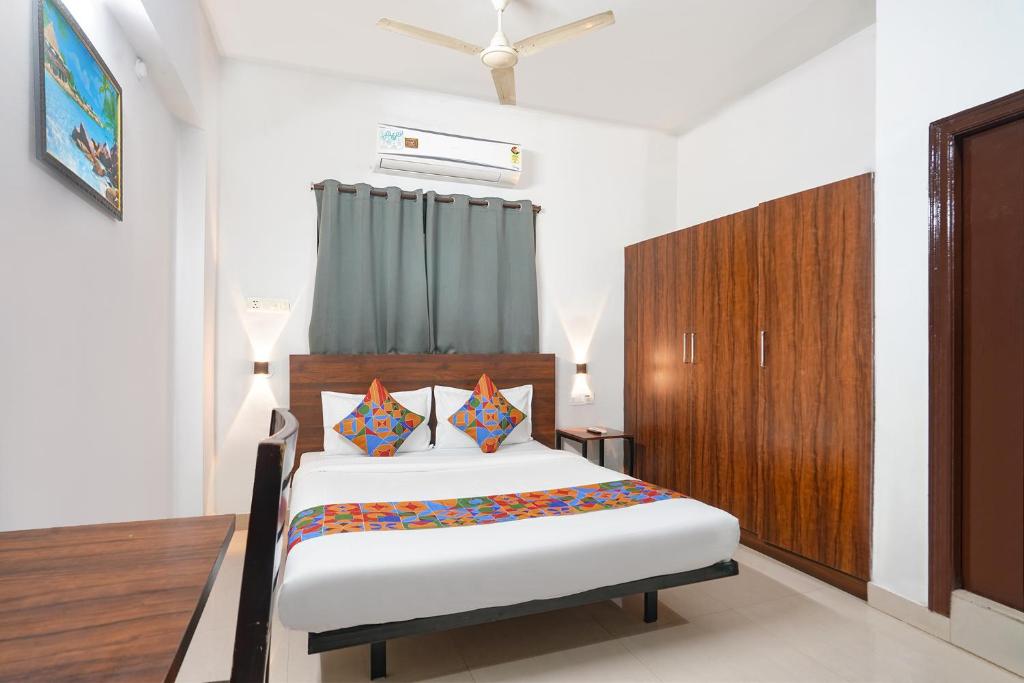 Un dormitorio con una cama y un armario de madera. en FabExpress Dream Nest, en Hyderabad