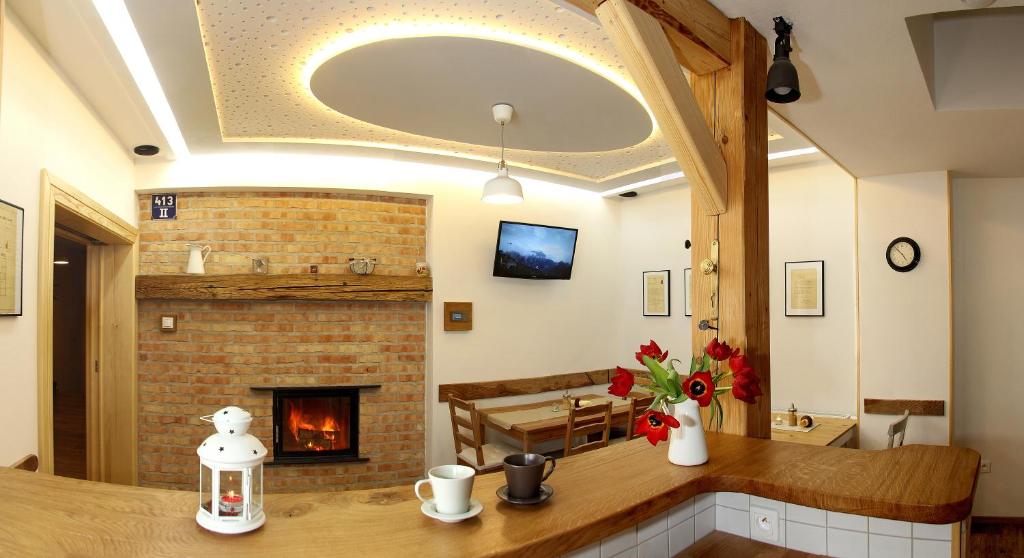 a kitchen with a fireplace and a table with flowers at Penzionek JH in Jindřichŭv Hradec