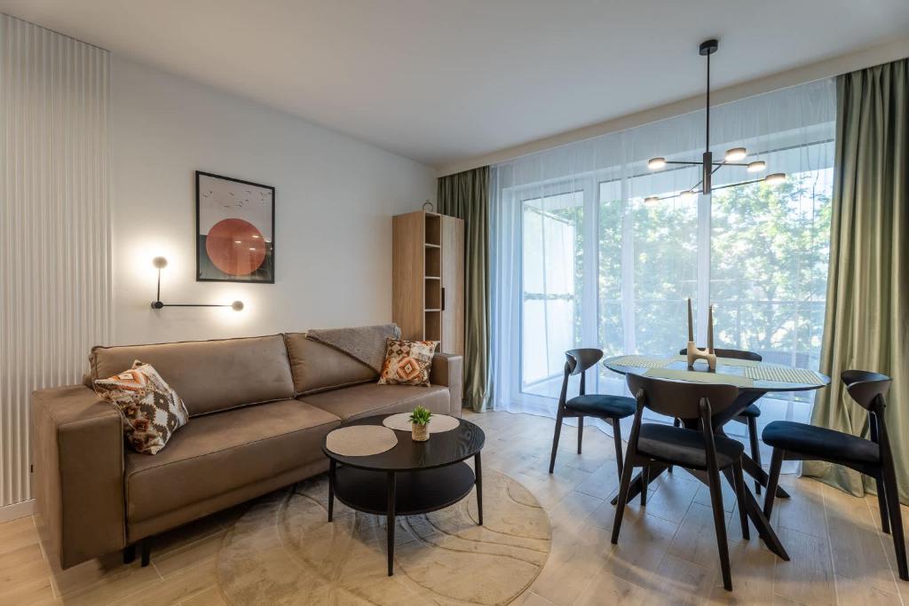 a living room with a couch and a table at Przytulne Studio Sikorskiego Balkon i Parking by Noclegi Renters in Kielce