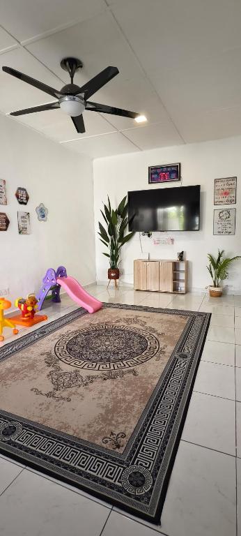 a living room with a ceiling fan and a rug at Homestay Cinta Kasih Mus'lim Only in Klang