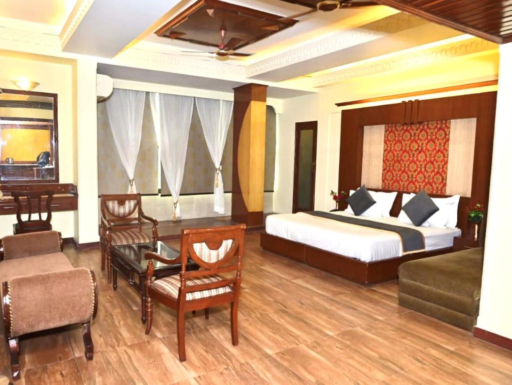 a hotel room with a bed and a table and chairs at Hotel Metro Regency Meerut in Meerut